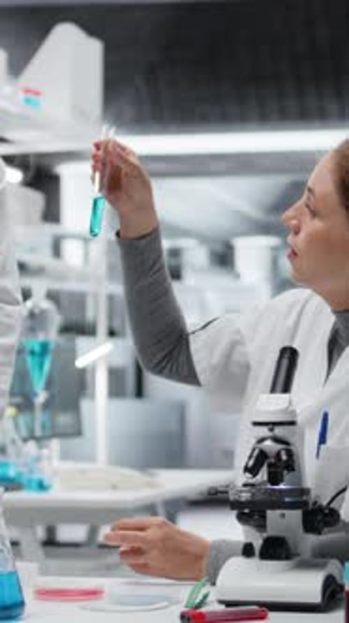 Vidéo verticale Les technologues de laboratoire clinique en laboratoire évaluent des solutions composées