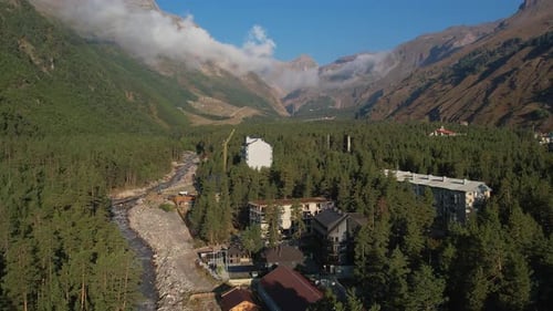 Aerial View of a Mountain Town with River and Green Valley