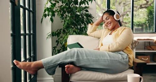 Woman Relaxes with Tablet and Headphones at Home
