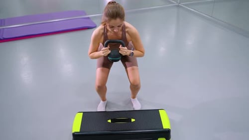 Aerial View of Woman Lifting Weight in Gym with Mirror and Yoga Mat