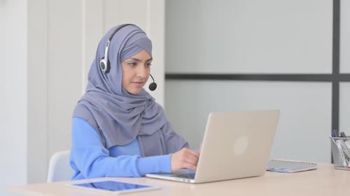 Muslim Woman in Hijab with Headset Talking with Customers Online in Call Center