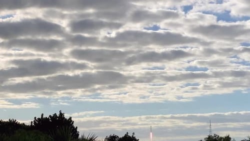 A view of a rocket taking off and flying into space through the clouds.