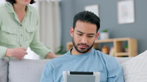 Affectionate Couple Relaxing on Sofa with Tablet