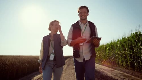 Smiling Farmers Walking Farmland on Sunny Day. Happy Agrarian Team at Field