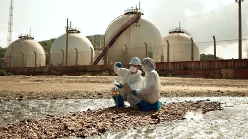 Researchers Testing Contaminated Water Near Industrial Tanks