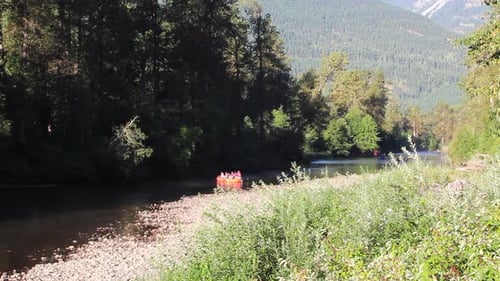 Sparren in orangefarbenen Booten fahren den malerischen morgendlichen Gebirgsfluss hinunter
