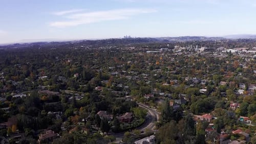 Aerial descending shot of Pasadena neighborhood with Downtown Los Angeles in the background. HD at 6