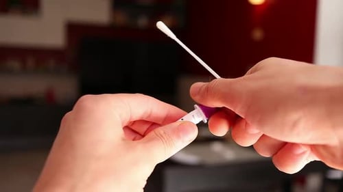 opening the tube containing the reagent liquid for the covid test, close up shot