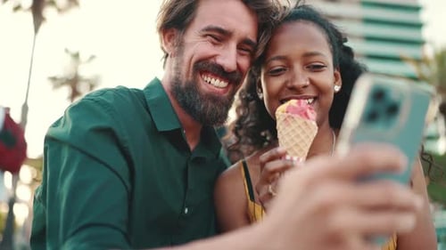 Close up of happy man and smiling woman watching video on smartphone