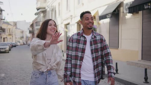 Multiethnic Couple in Love Walks Along the Narrow Streets of a European City The Guy and the Girl
