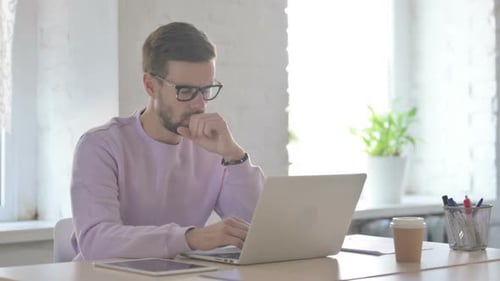 Young Adult Working at Desk with Laptop