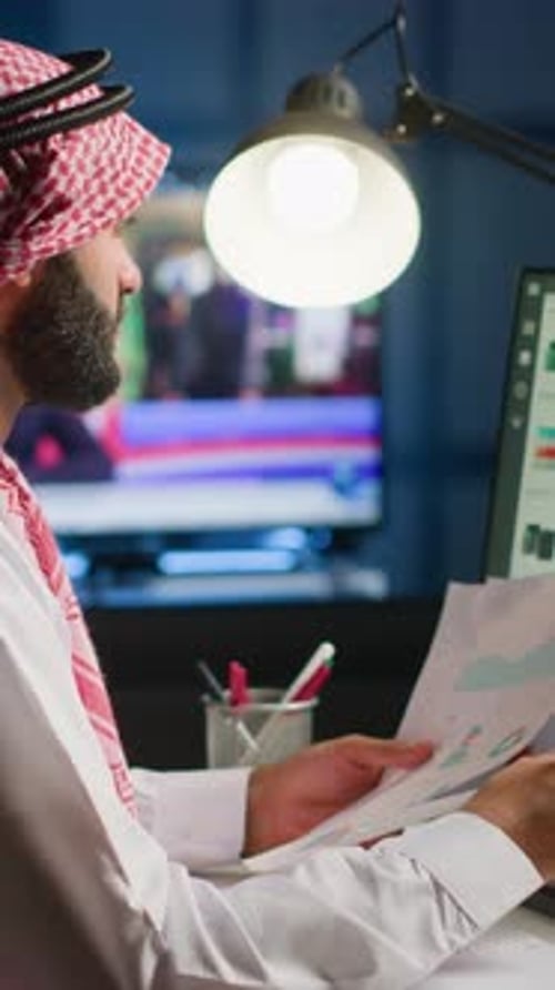 Man Reviews Papers at Desk Late at Night