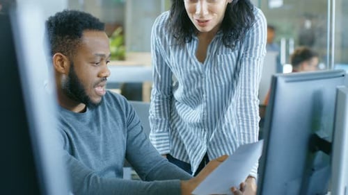 In the Busy Corporate Office Male and Female Have Work Related Discussion, Using Personal Computer.