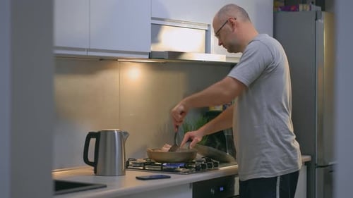Man Cooking Fried Chicken Meat in Pan in Kitchen for Family Dinners
