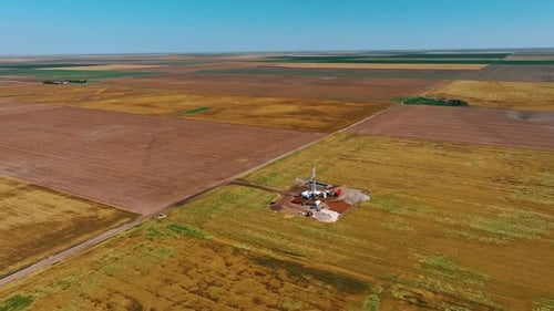 Immense plantation divided into the fields. Flying closer to the site for drilling oil, gas