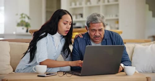 Woman Showing Senior Man How To Use Laptop