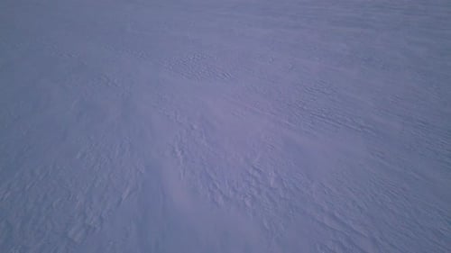 Aerial Drone View of a Snowcovered Surface with Windsculpted Patterns The Untouched Winter Landscape