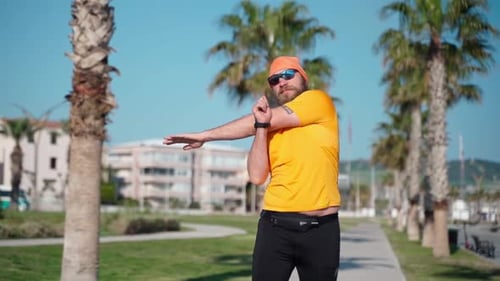 Man Stretches on Palm Tree-Lined Sidewalk
