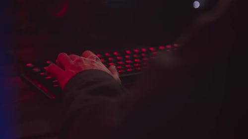 Hände des Spielers mit Tastatur mit roter LED-Hintergrundbeleuchtung