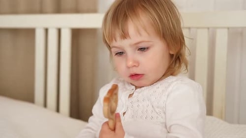 Young Blonde Child Playing With a Wooden Toy