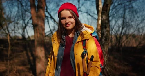 Backpacker Hiker Girl with Hiking Poles Walking Between Trees in a Mountain Forest Hispanic Teenager
