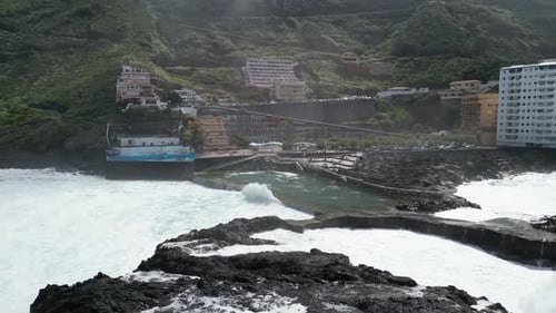 Natural seawater pool in Mesa del Mar, Tenerife Canary islands Spain with bathers inside, Aerial app