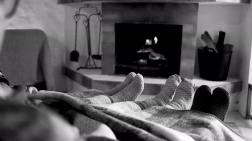 Feet in Socks Relaxing by Cozy Fireplace
