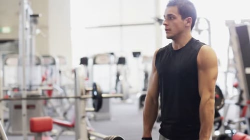 Sport Bodybuilding Lifestyle and People Concept - Young Man with Dumbbell Flexing