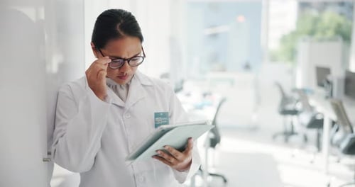 Woman in Lab Coat Using Tablet in Bright Office
