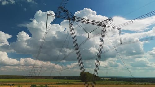 Hochstehender Strommast in ländlicher Landschaft unter bewölktem Himmel