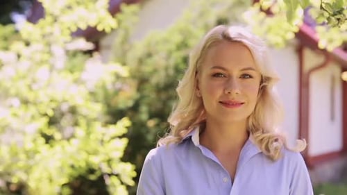 Happy smiling woman enjoys summer in her beautiful garden with slow motion