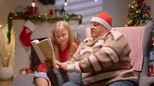 Child and Adult Reading Book at Christmas