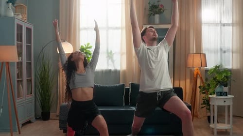 Couple Practicing Yoga Poses in Living Room