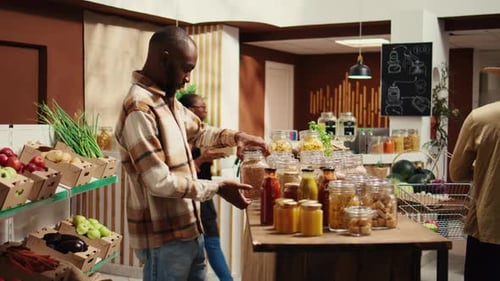 Male Customer Checking Types of Pasta or Grains at Local Market