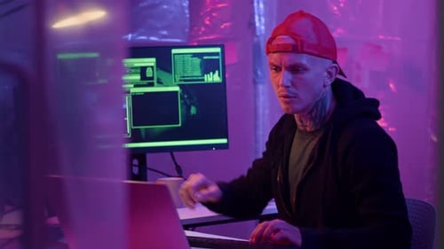 Man Coding at a Computer in Dark Room