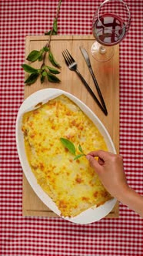 Overhead Shot of Lasagna Being Garnished with Basil