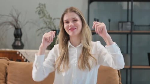 Happy Woman Dancing on Couch at Home