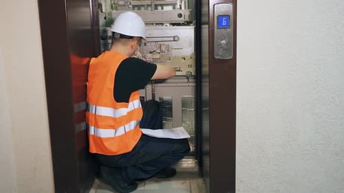 Elevator Mechanic Inspecting Lift System in Shaft