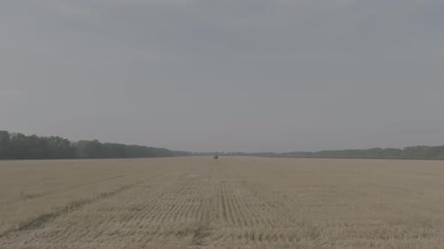 Farmer on Tractor Fertilizing Agricultural Field Spreading Mineral Fertilizer in Slow Motion Tractor