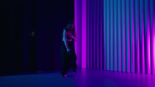 Young Woman Dancing Jazz Funk And HipHop Dance In Studio With Neon Lights Modern Choreography