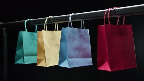 Colorful Shopping Bags Hanging on Bar in Studio