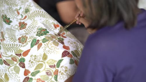 close up, women make batik fabrics in a traditional, flexible way.