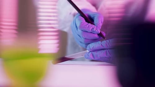 Gloved Hand Writes on Test Tube in Lab
