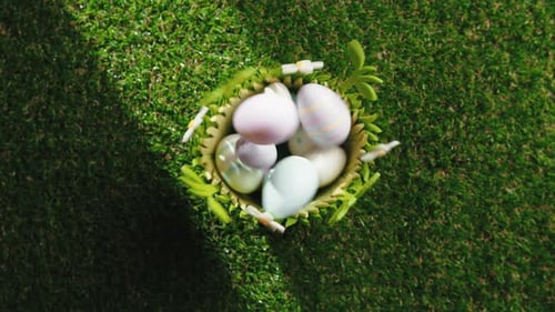 Easter Eggs Falling into Easter Basket on Grass