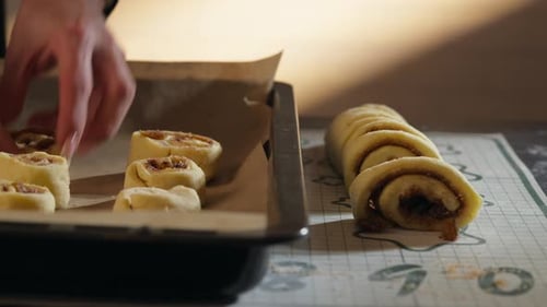 Woman Preparing Delicious Cinnamon Rolls on Baking Sheet
