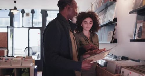 Store owner helping customer in a record store