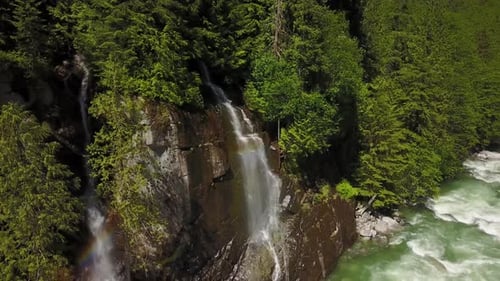 An einem strahlend sonnigen Frühlingstag fließt eine Flussströmung durch das Tal rund um die glatten Felsen