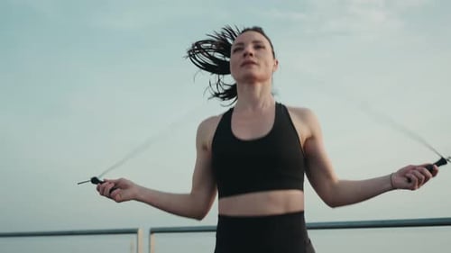 Mujer activa haciendo ejercicio de salto de cuerda al aire libre