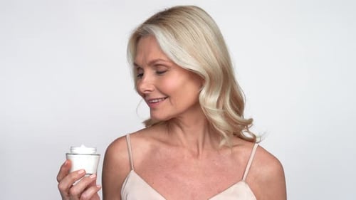 Woman Applies Face Cream for Beauty and Skincare