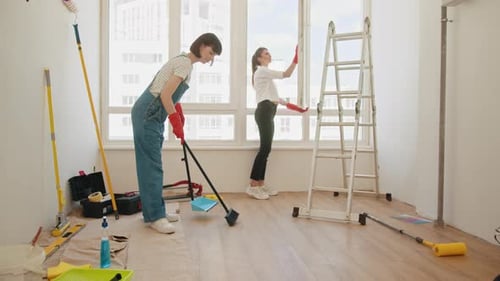 Two Women Repainting Apartment and Sweeping Floor